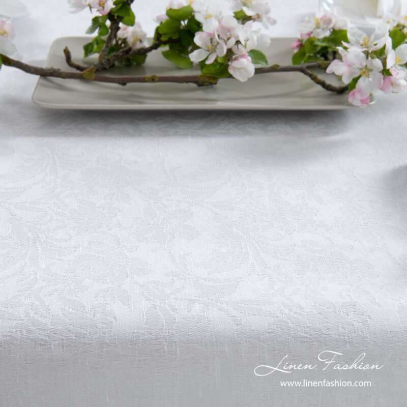 Optical white linen / cotton tablecloth decorated with intricate flower motif ornaments