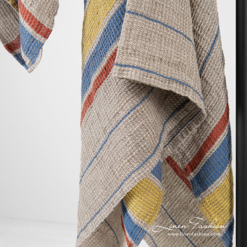 Linen cotton beige bath towel with yellow, blue, red stripes.