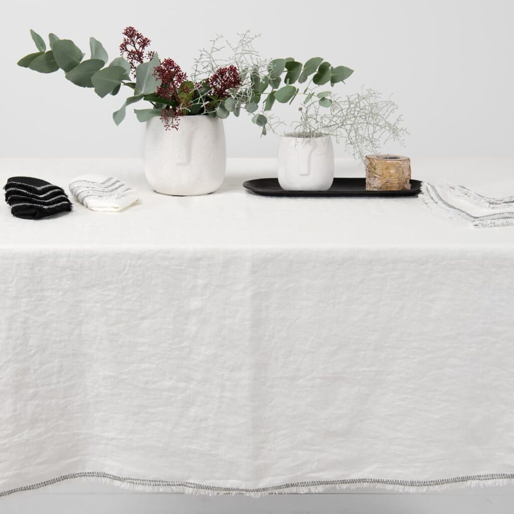 ALBA Tischdecke weiß 6 white linen tablecloth with decorative seam with loose fringes.
