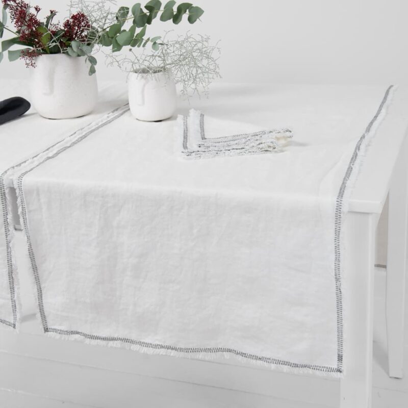 white linen runner with decorative stitch, washed.