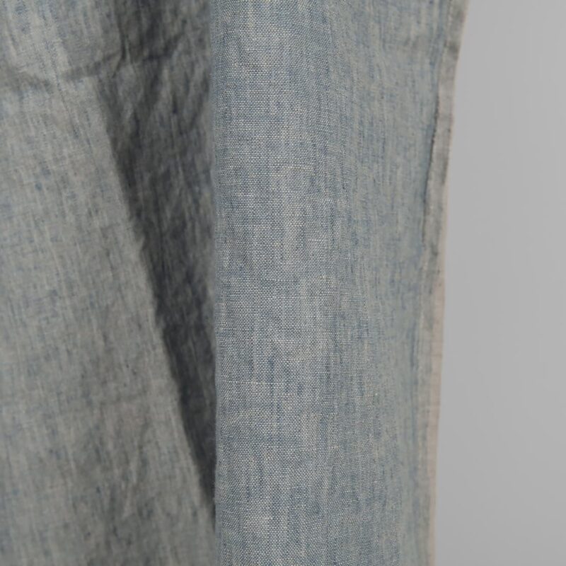 Linen washed fabric grayish blue color for sewing clothes and home textiles close edge view