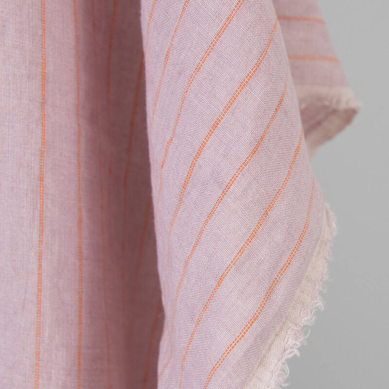 Washed linen fabric lilac with orange stripes, fabric edge