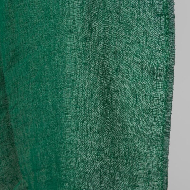 Washed linen fabric emerald green transparent close up edge view