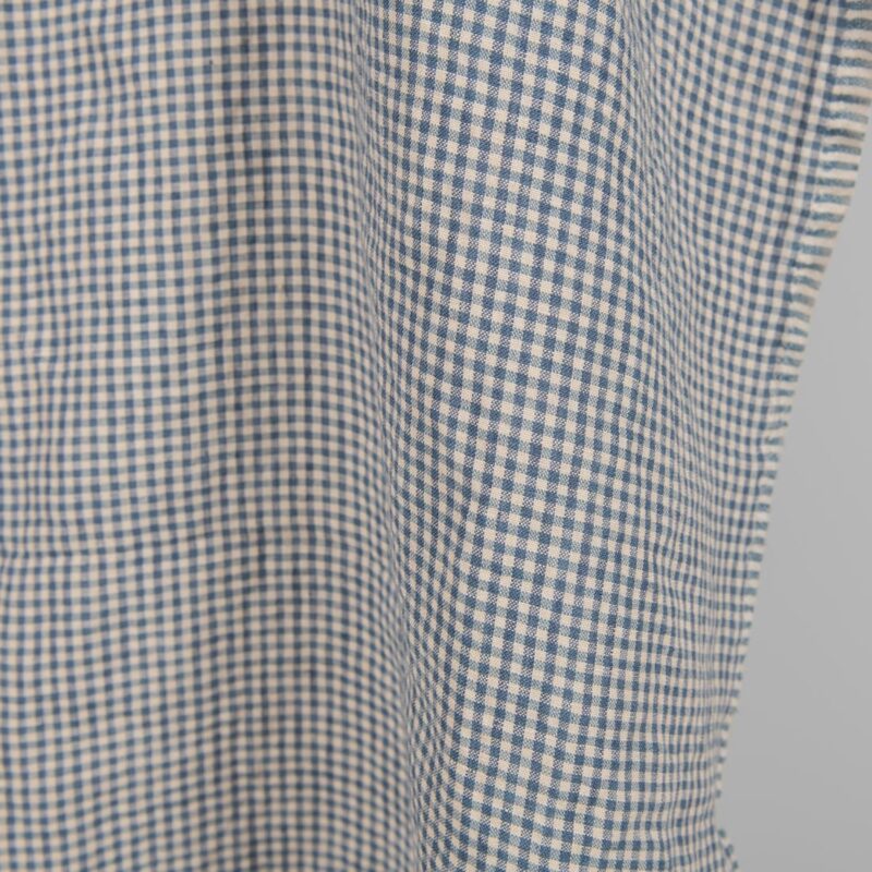 Washed linen fabric with small blue and brownish checks close edge view