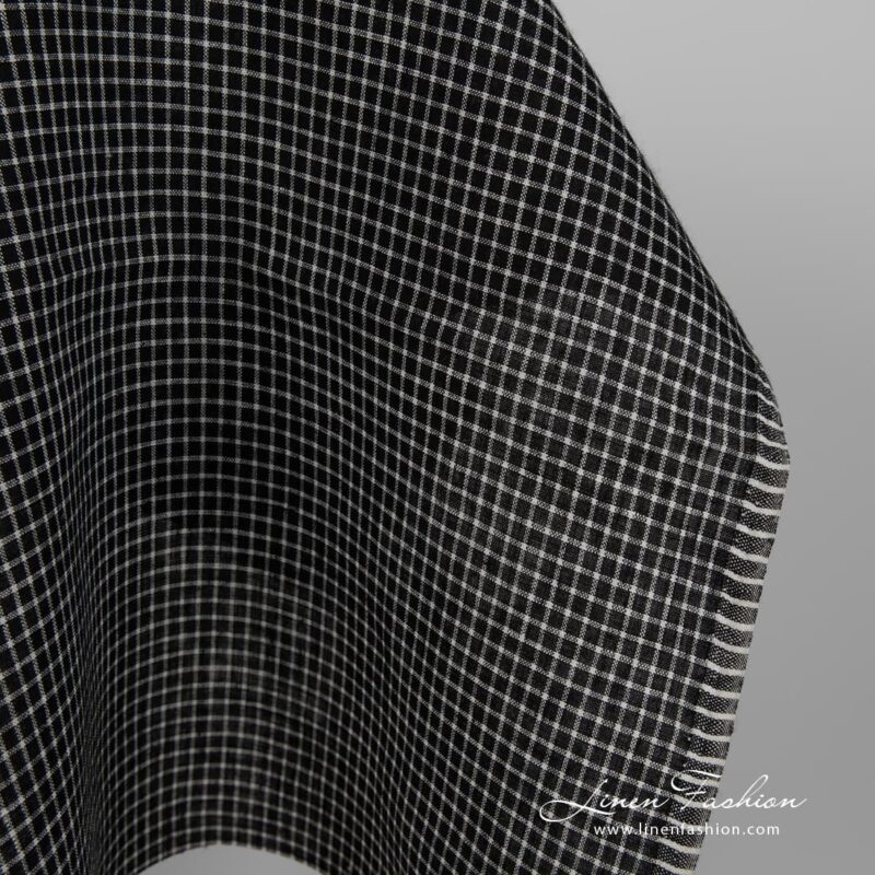 Black linen fabric with white checks close up edge view