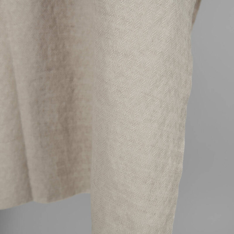 Washed linen cotton sand colour herringbone pattern close up edge view