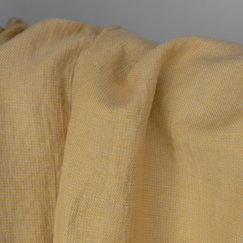 Washed linen cotton fabric in yellow-sand small pattern close up detail