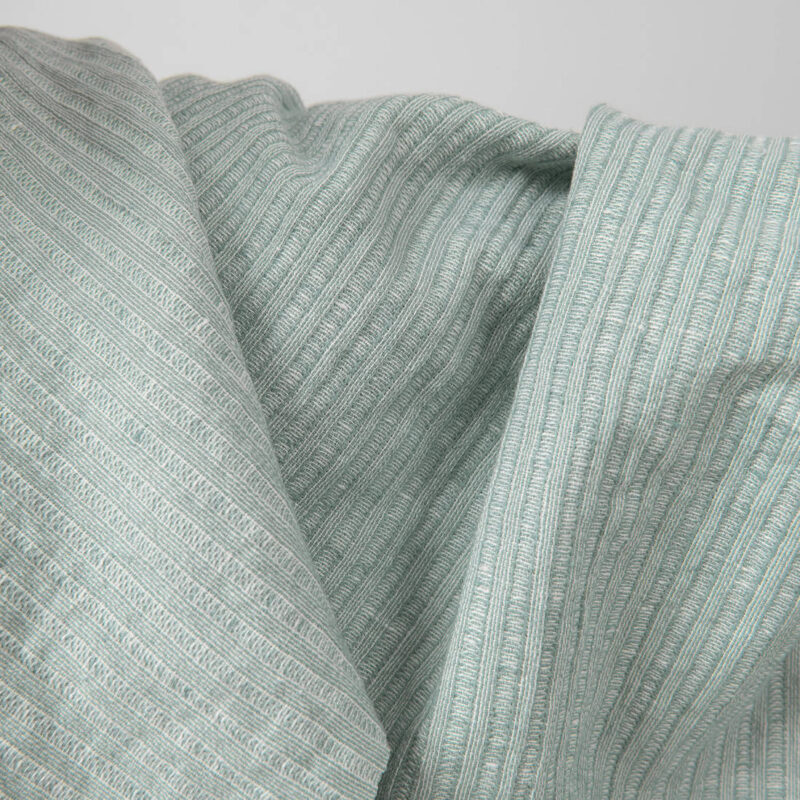 Washed linen cotton fabric greenish white colour striped close up detail