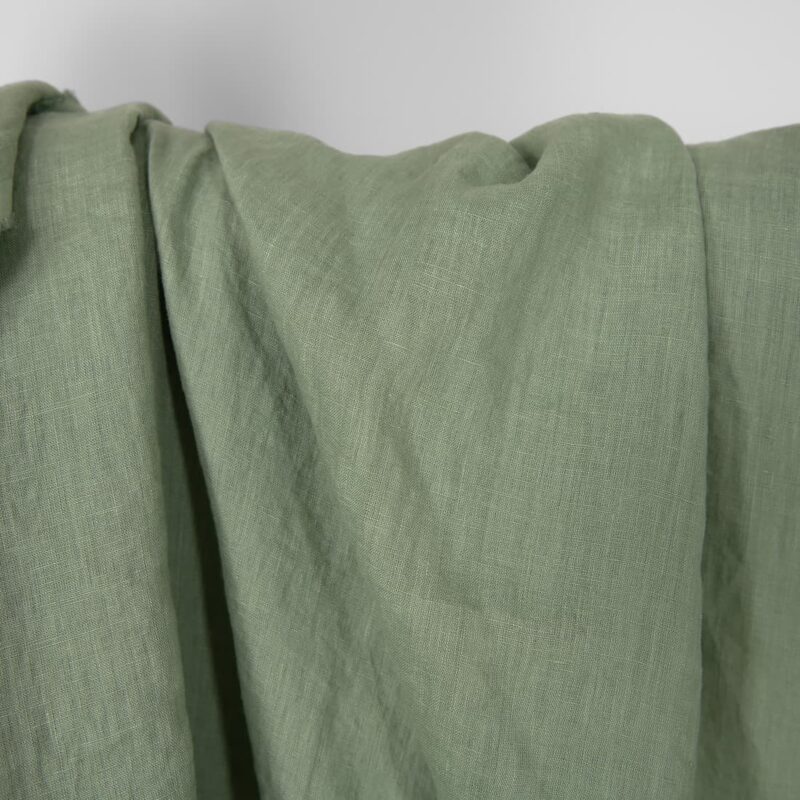 Washed linen fabric in muted light green, plain weave