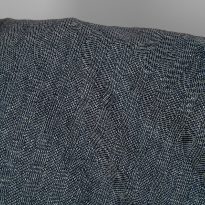 Washed linen wool fabric black white in herringbone pattern close up detail