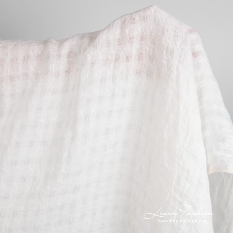 Off-white linen fabric in transparent checks, specially washed to increase softness